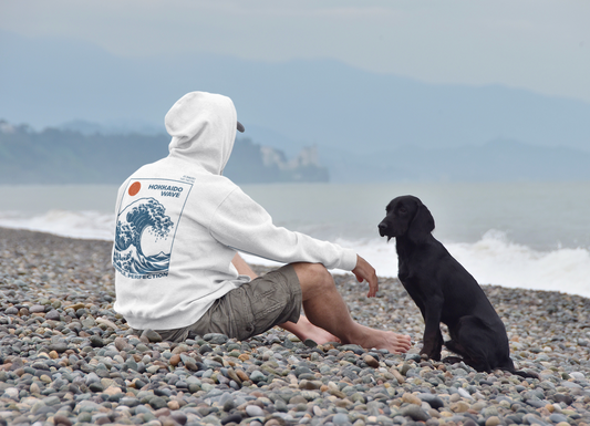 Man sitting on the beach wearing a white hoodie made from 100 percent cotton ats pr-shrunk