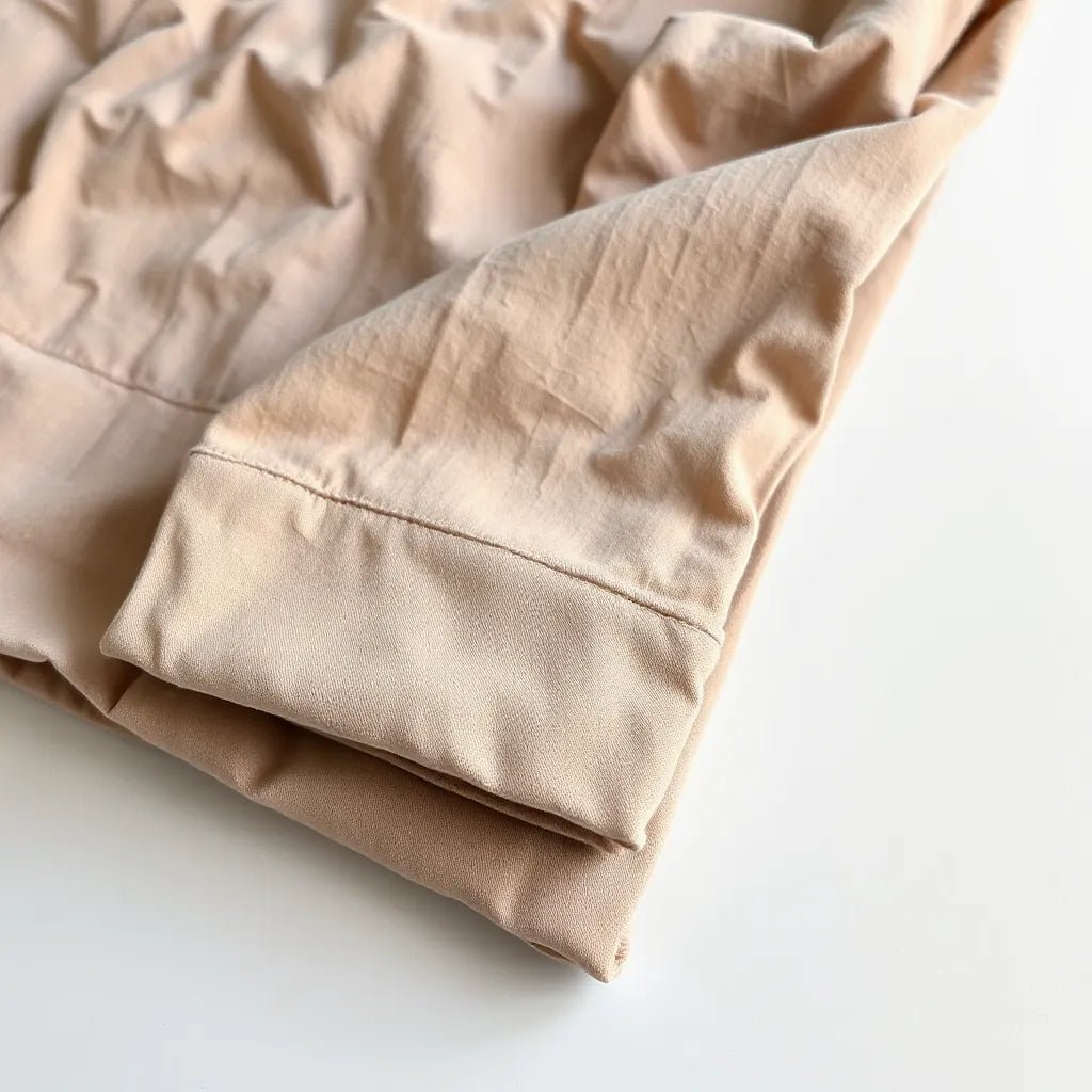 Folded garment dyed cotton shirt showing soft fabric texture and subtle color variation on a light background