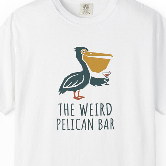 White t-shirt with a pelican graphic and text 'The Weird Pelican Bar' on a white background