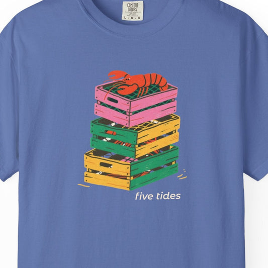 Blue t-shirt with colorful crate design and 'five tides' text on a white background