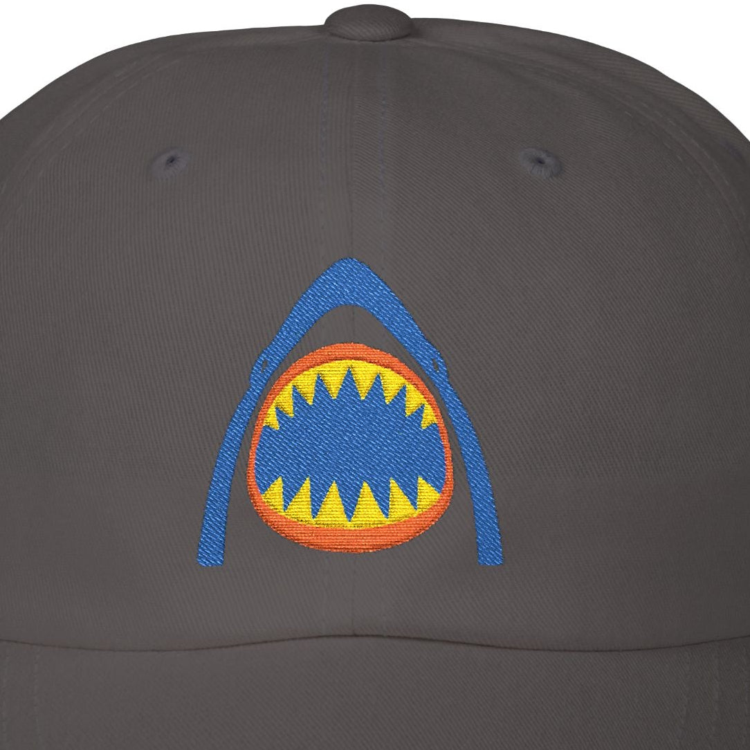 Black cap with a colorful shark mouth design on a white background