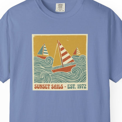 Blue t-shirt with a sailboat graphic and 'Sunset Sails' text on a white background