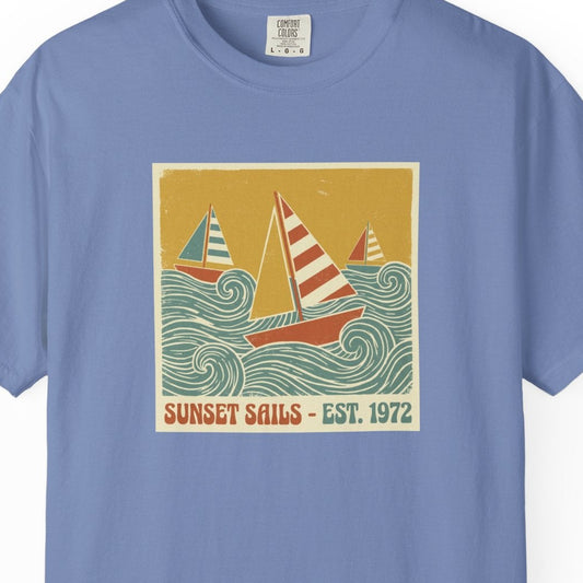 Blue t-shirt with a sailboat graphic and 'Sunset Sails' text on a white background