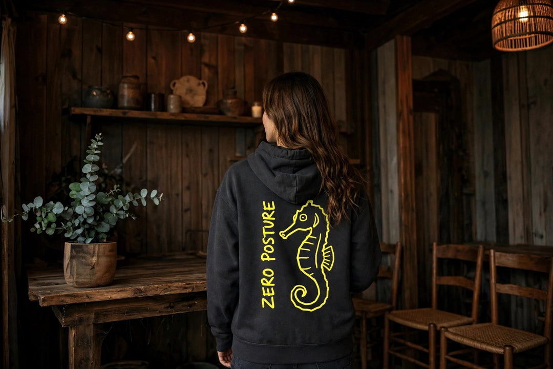 Neon Seahorse Hoodie — in the Five Tides room, female back