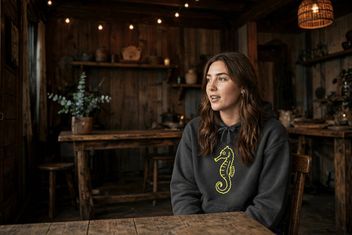 Neon Seahorse Hoodie — in the Five Tides room, female front