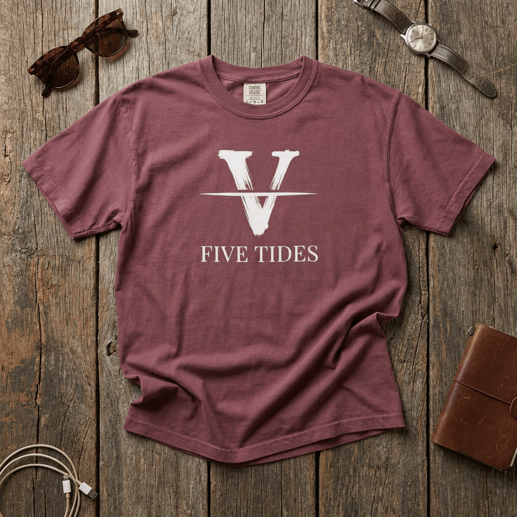 Maroon t-shirt with 'Five Tides' logo on a wooden surface with accessories.