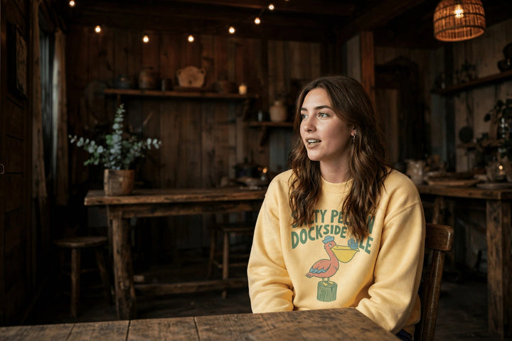 Salty Pelican Sweatshirt — in the Five Tides room, female front
