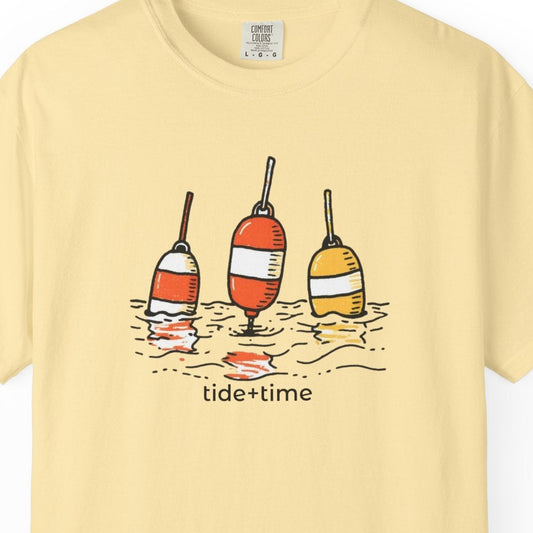 Yellow t-shirt with graphic of three buoys and 'tide + time' text on a white background