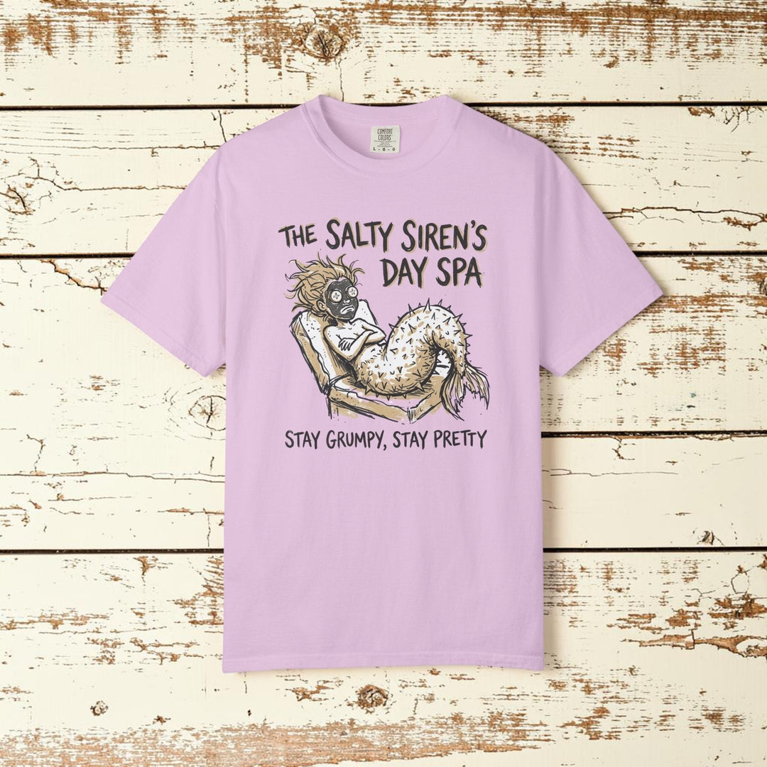 Pink t-shirt with a mermaid graphic and text on a white background