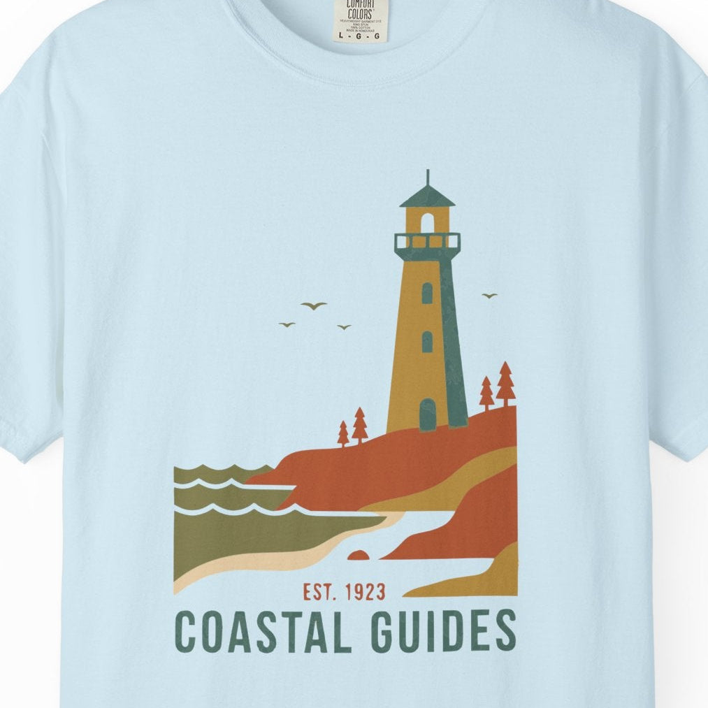 Light blue t-shirt with a lighthouse graphic and 'Coastal Guides' text on a white background
