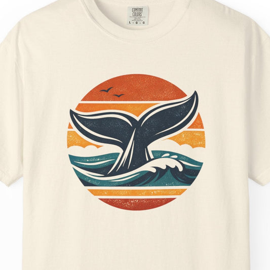 Beige t-shirt with a whale tail design on a white background