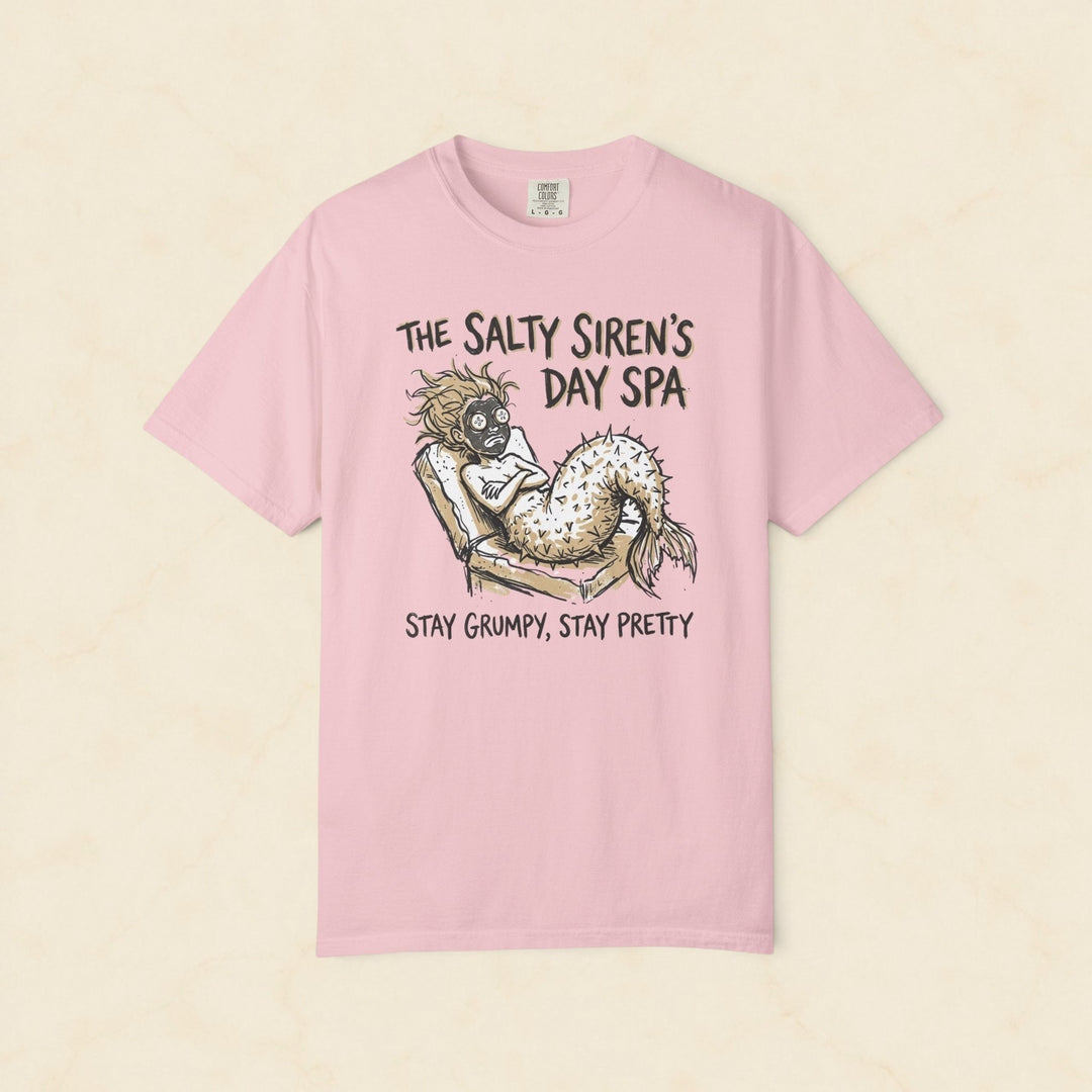 Pink t-shirt with mermaid graphic and text on a white background