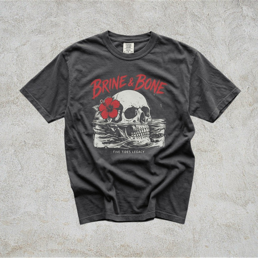 Gray t-shirt with skull and flower graphic on a concrete surface