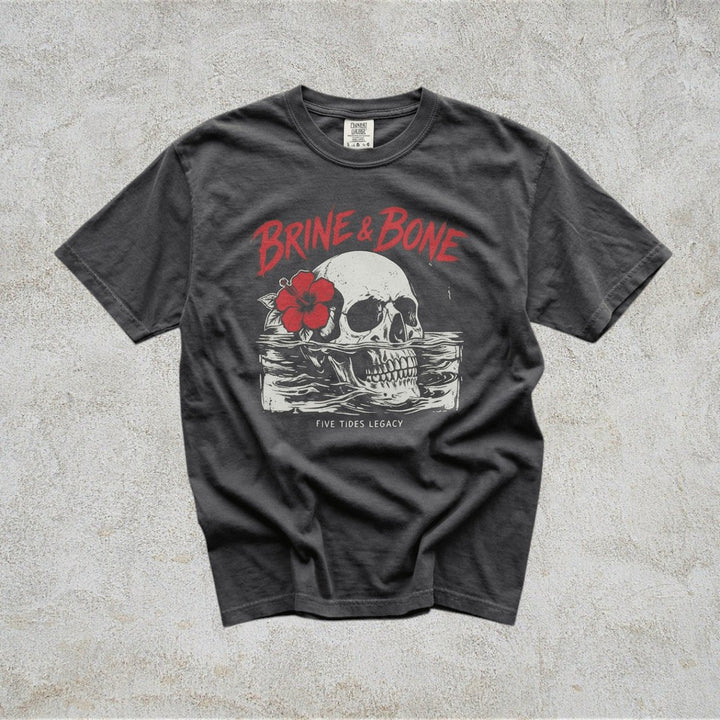 Gray t-shirt with skull and flower graphic on a concrete surface