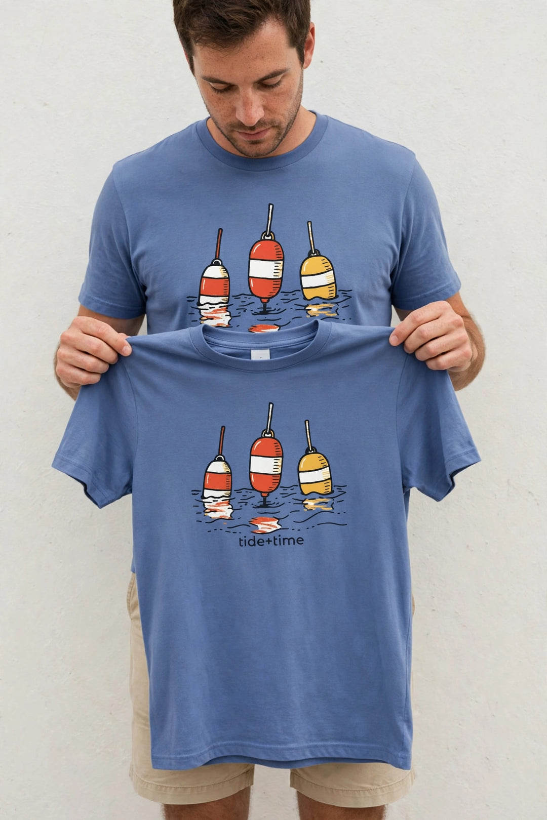 Man wearing the Beach Buoy Graphic Tee in Mystic Blue, holding up the front print.