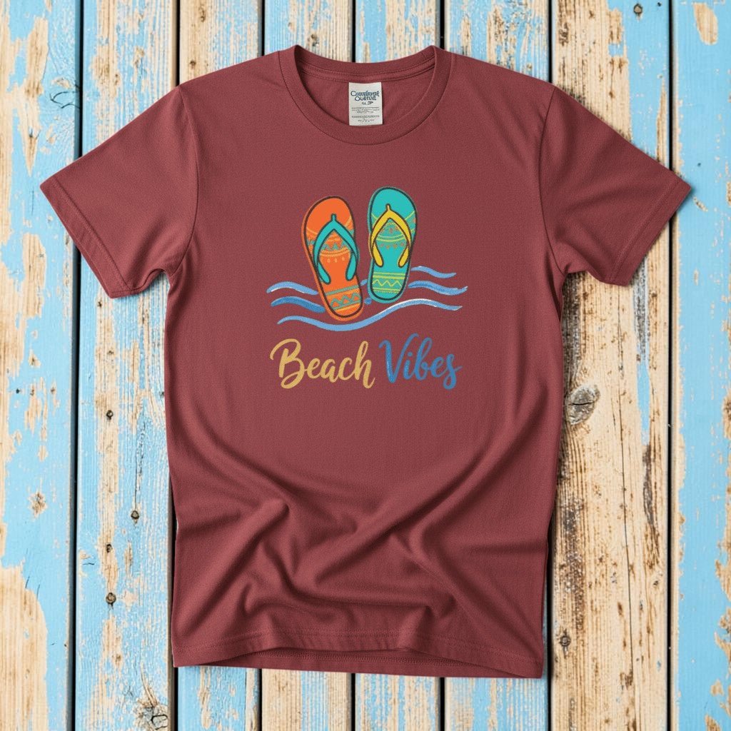 Flat lay - crimson red Beach Vibes tee with Comfort Colors label on weathered driftwood planks