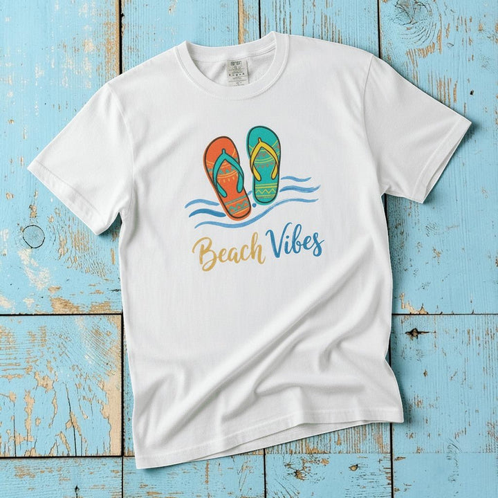 Flat lay - white Beach Vibes tee with Comfort Colors label on weathered driftwood planks