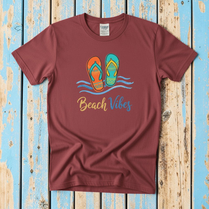 Flat lay - crimson red Beach Vibes tee with Comfort Colors label on weathered driftwood planks