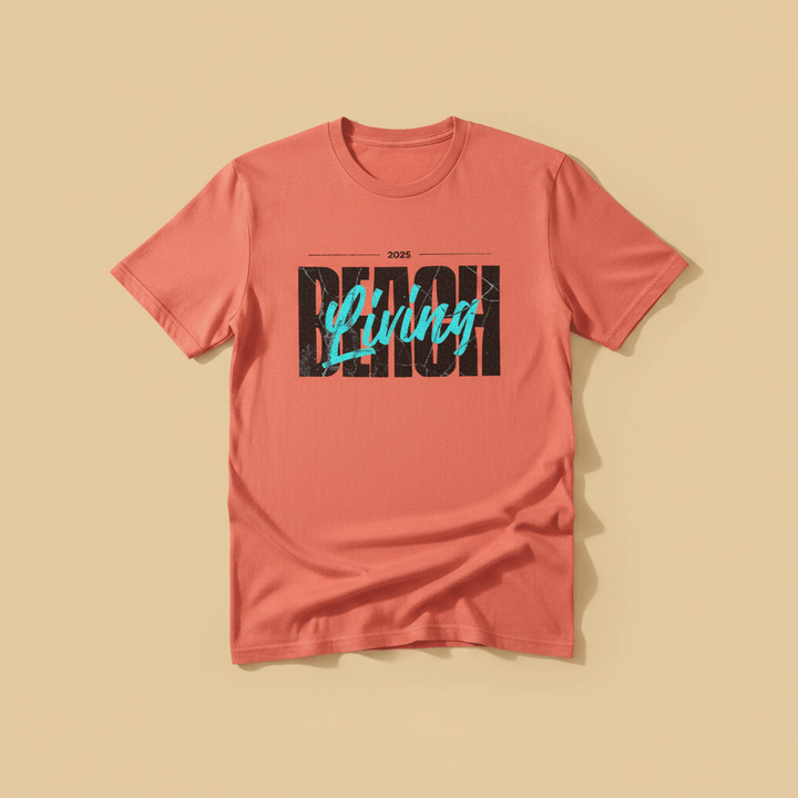 Beach Living Tee in Coral — front graphic, warm sand studio background