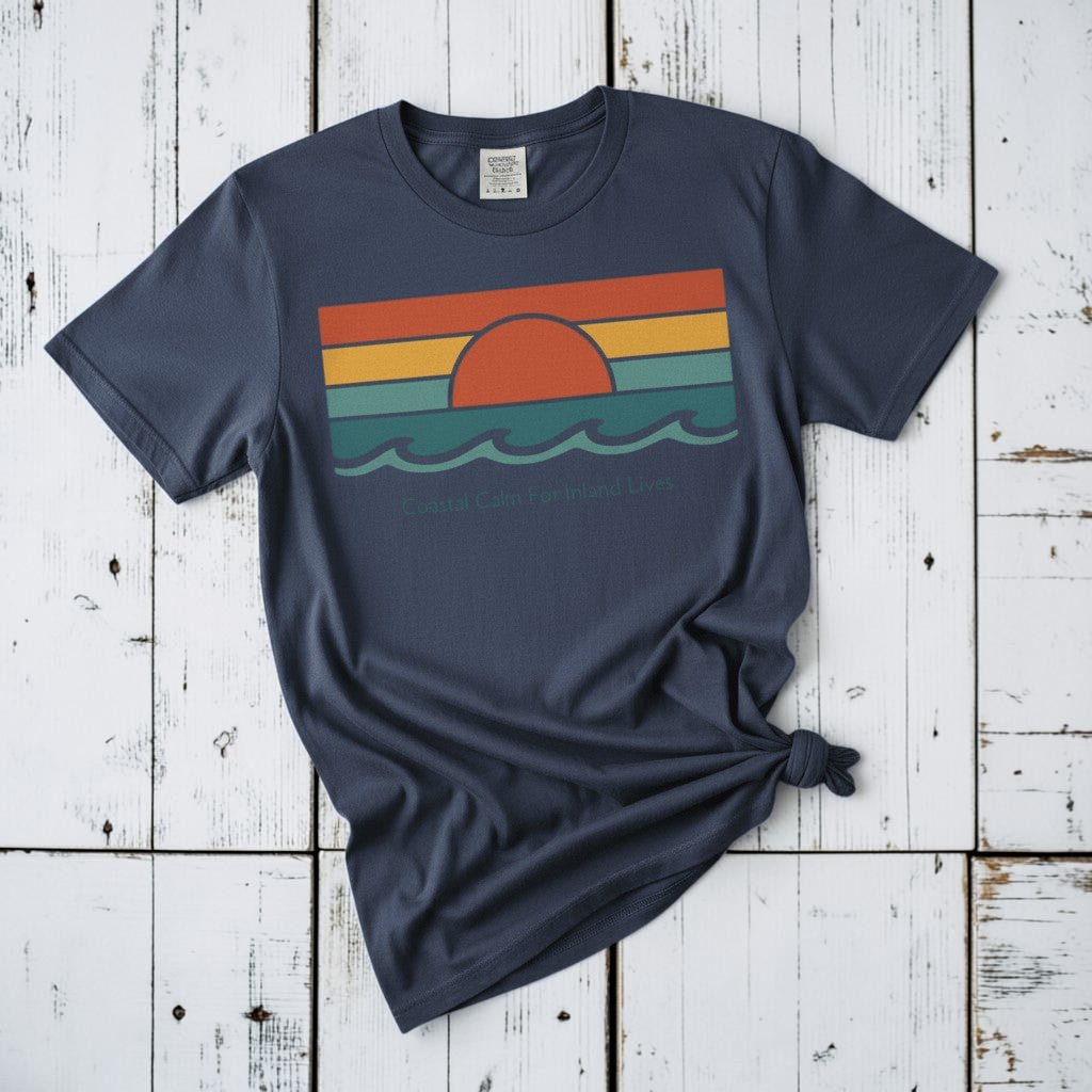 Coastal Calm for Inland Lives midnight garment-dyed tee on faded driftwood planks