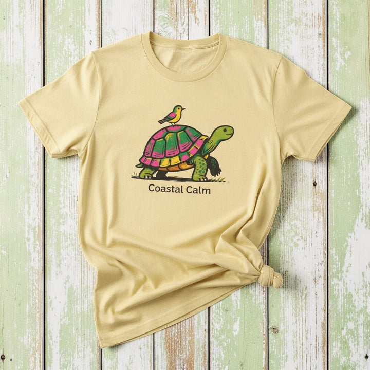 Coastal Calm Turtle Buddies banana garment-dyed tee on faded driftwood planks
