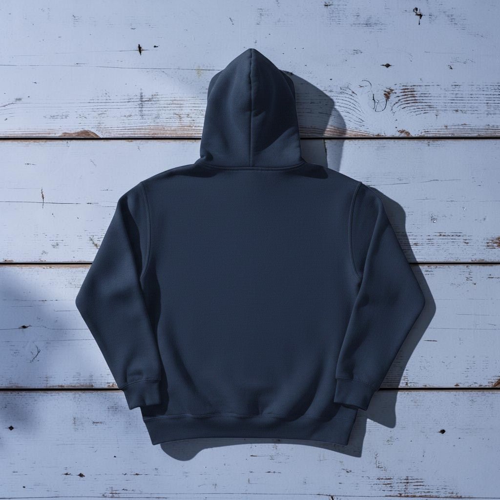 Coastal Lighthouse Hoodie in True Navy — plain back, warm sand studio background