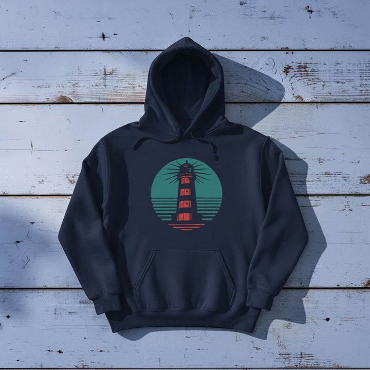 Coastal Lighthouse Hoodie in True Navy — front graphic, warm sand studio background