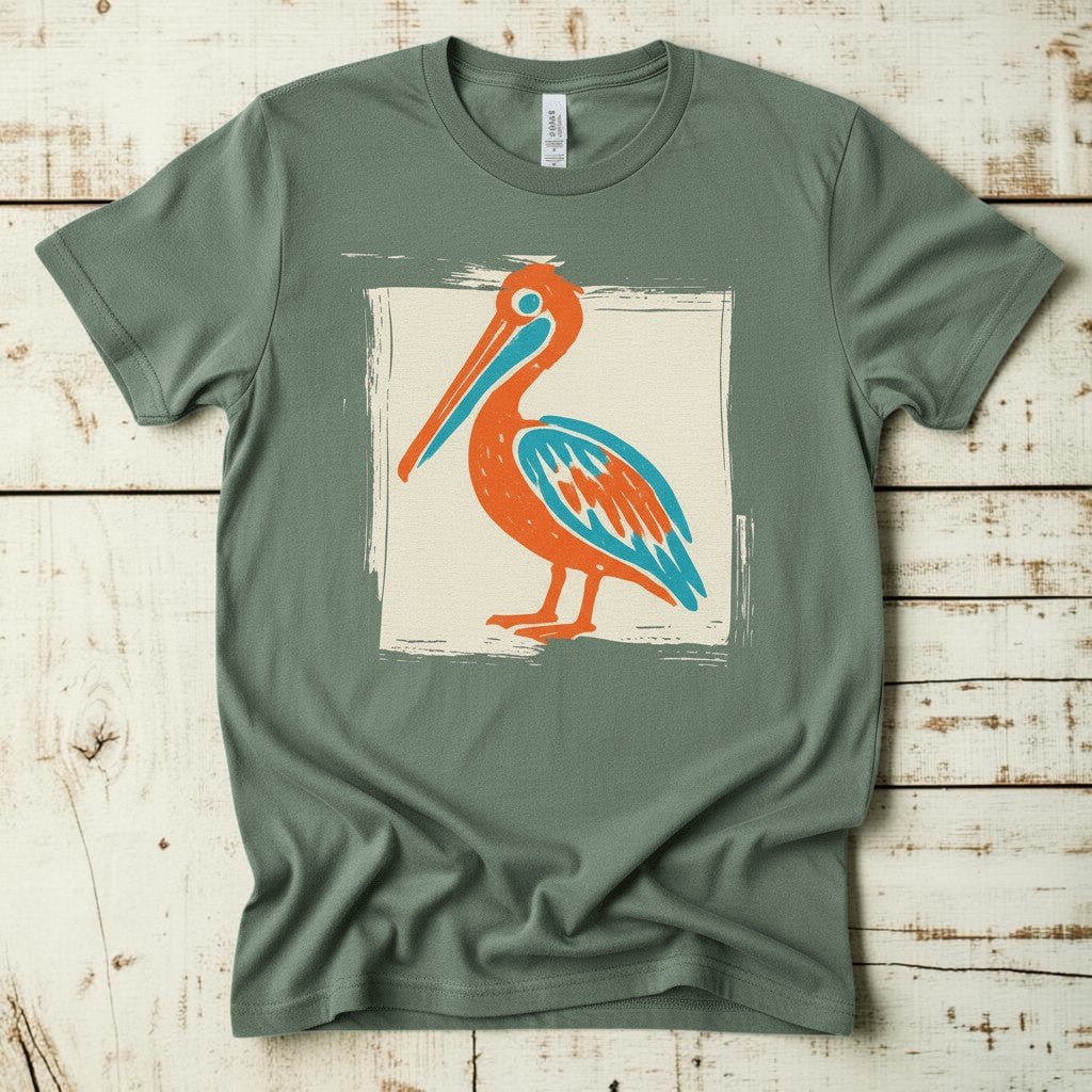 Colorful Beach Pelican sage garment-dyed tee on faded driftwood planks
