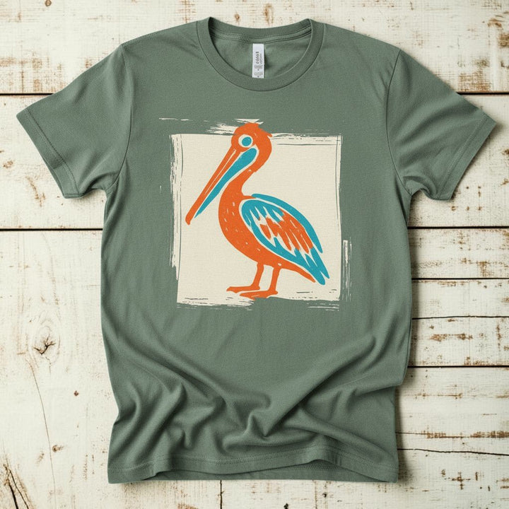 Colorful Beach Pelican sage garment-dyed tee on faded driftwood planks