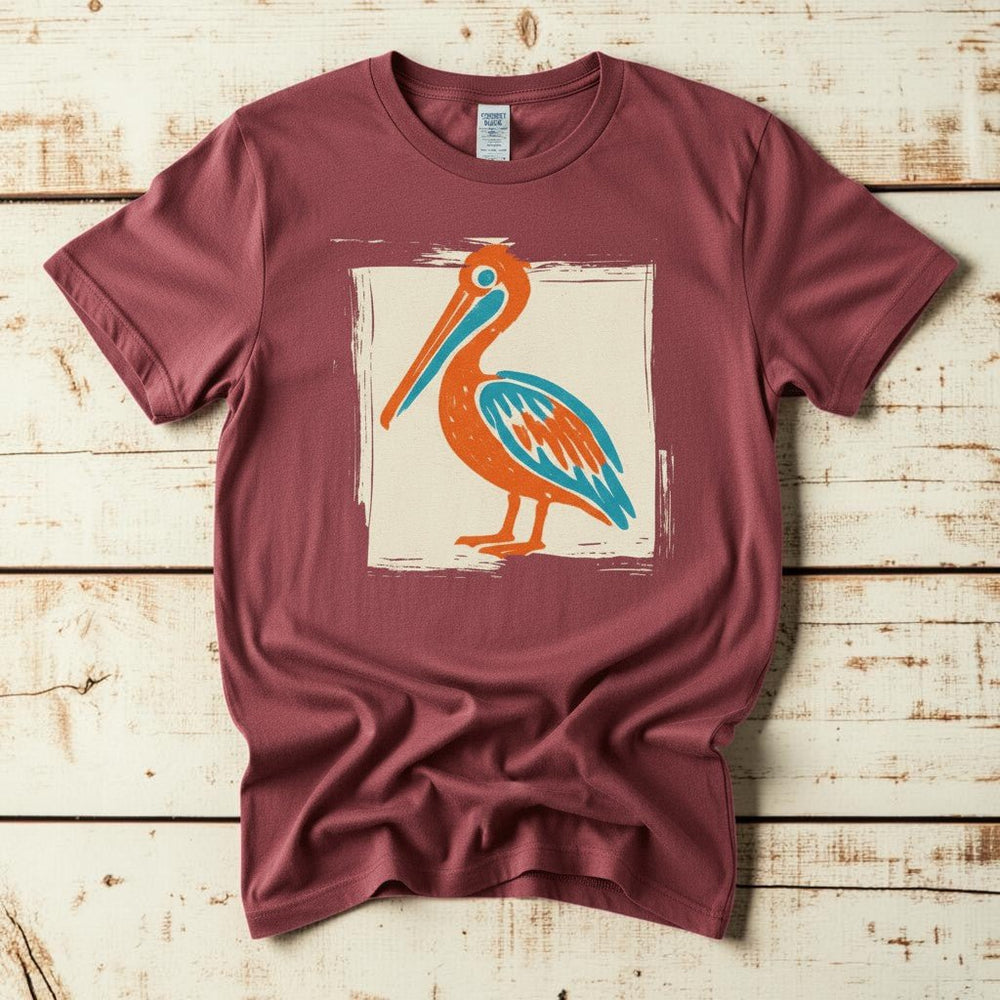 Colorful Beach Pelican chili garment-dyed tee on faded driftwood planks