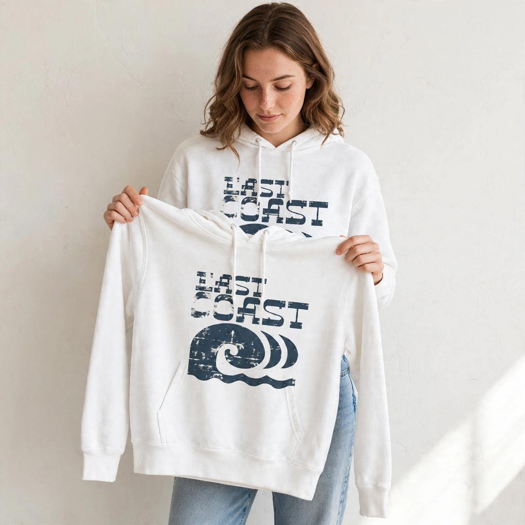 Woman wearing the East Coast Waves Hoodie in White, holding up the front print.