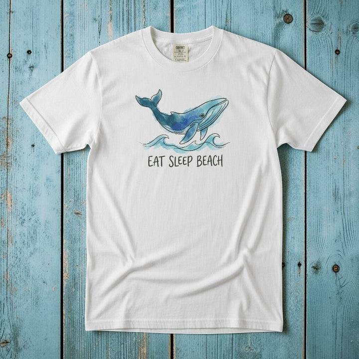 Flat lay - white Eat Sleep Beach tee with Comfort Colors label on weathered driftwood planks