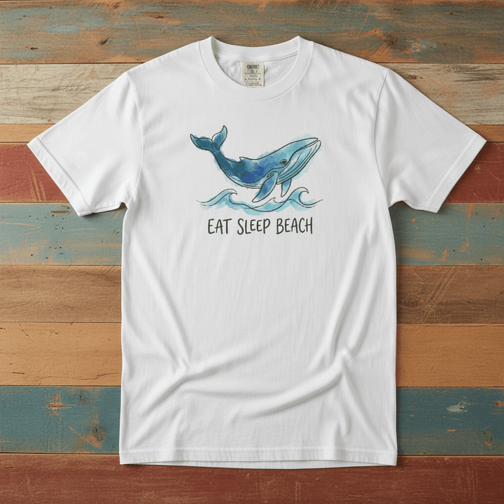 Flat lay - white Eat Sleep Beach tee with Comfort Colors label on weathered driftwood planks