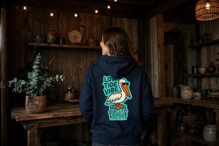 Low Tide Vibe Pelican Hoodie — in the Five Tides room, female back