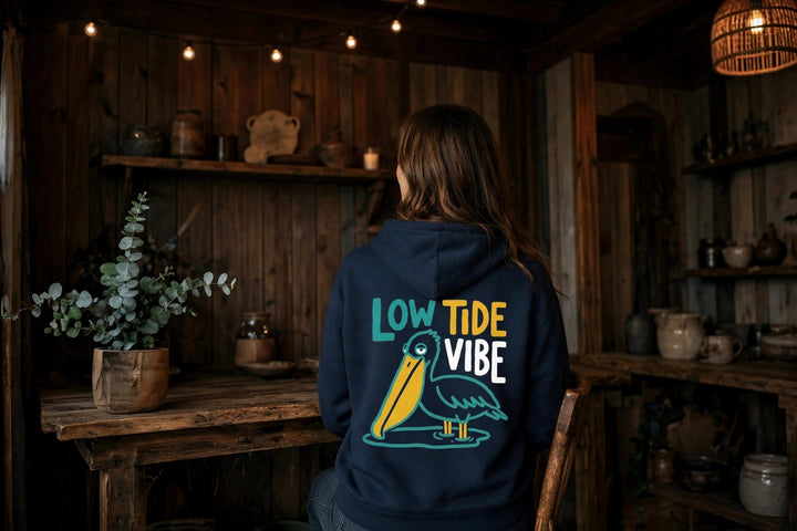 Low Tide Vibe Pelican Hoodie — in the Five Tides room, female back