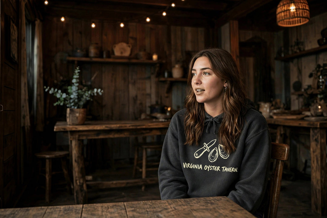 Virginia Oyster Tavern Hoodie — in the Five Tides room, female front
