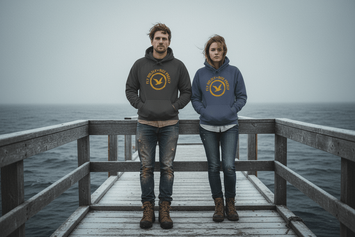 Couple wearing Fly Boldly hoodies in charcoal and denim on Maine coastal dock in winter
