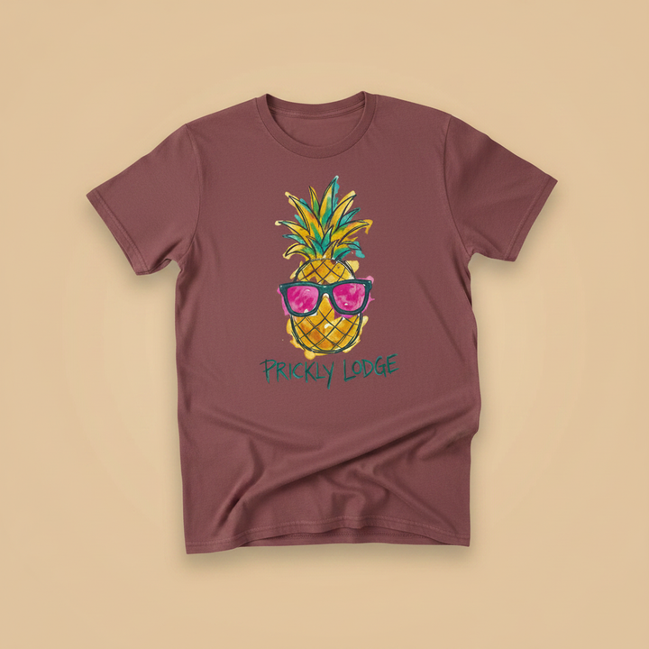 Prickly Lodge Pineapple Tee in Brick — front graphic, warm sand studio background