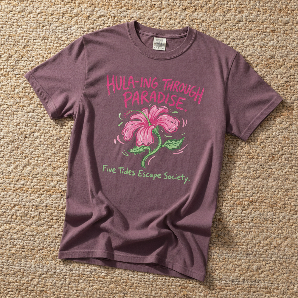 Hula-ing Through Paradise hibiscus floral graphic t-shirt in Berry deep pink casually tossed on a light sand-colored woven rug, tropical lifestyle product photo
