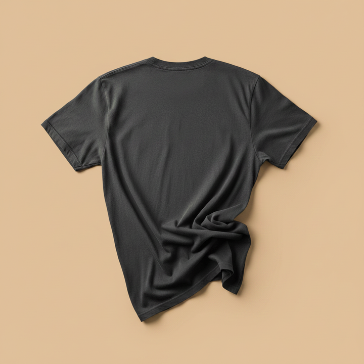 NOMAD Tee in Pepper/Charcoal — plain back, warm sand studio background