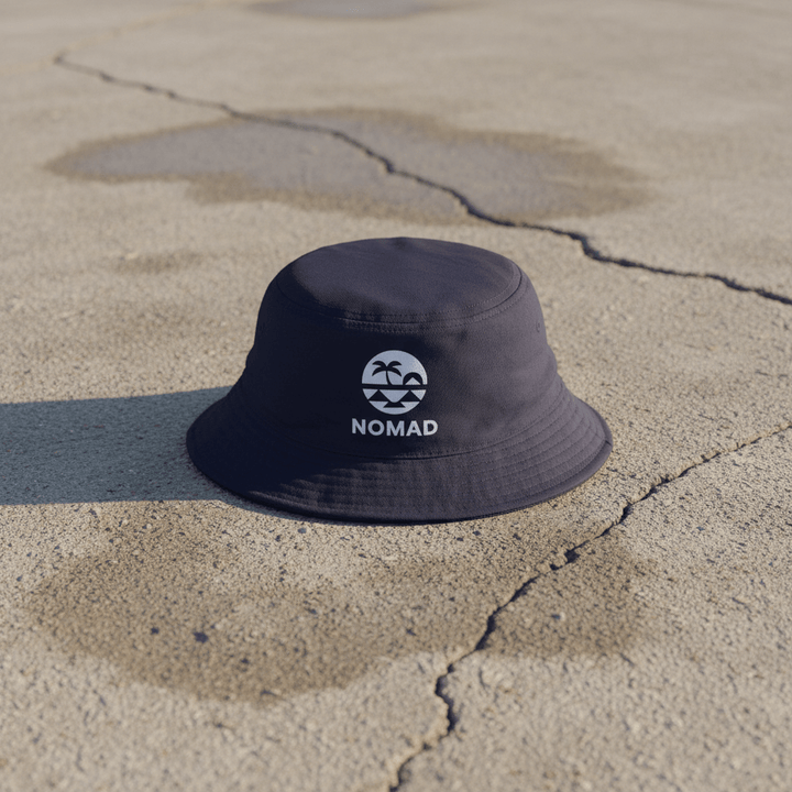 Nomad navy bucket hat on light cracked cement with wet marks