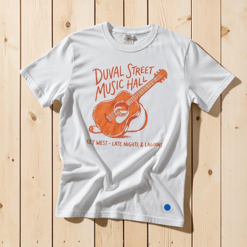 Duval Street Music Hall guitar graphic t-shirt in White casually tossed on a light sand-colored woven rug, Key West lifestyle product photo