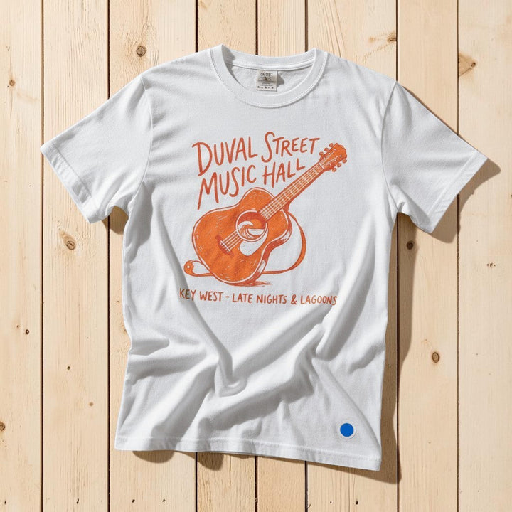 Duval Street Music Hall guitar graphic t-shirt in White casually tossed on a light sand-colored woven rug, Key West lifestyle product photo