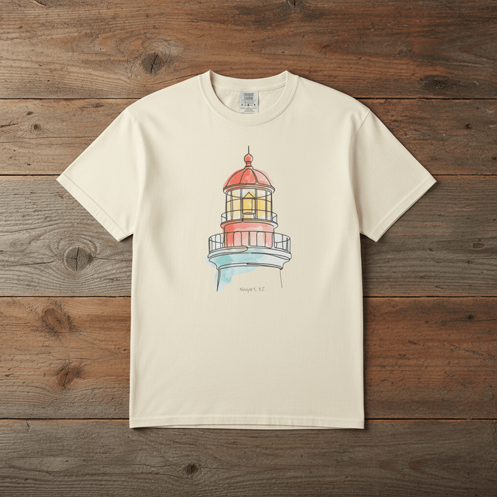 Lighthouse Watercolor ivory garment-dyed tee laid flat on rustic reclaimed wood