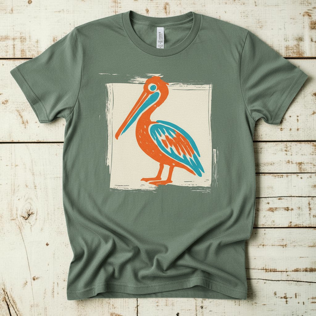 Colorful Beach Pelican sage garment-dyed tee on faded driftwood planks
