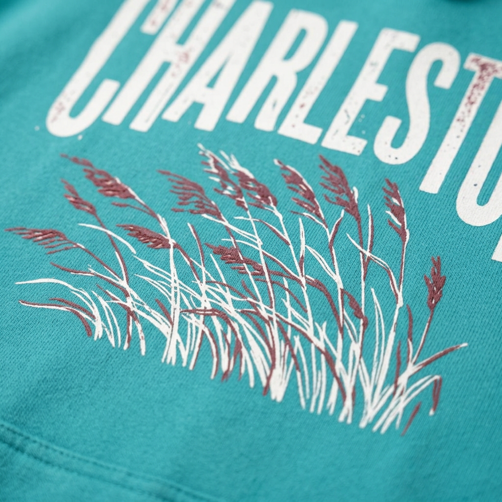 Charleston Sea Oats seafoam hoodie white lettering and plum sea oats graphic close-up