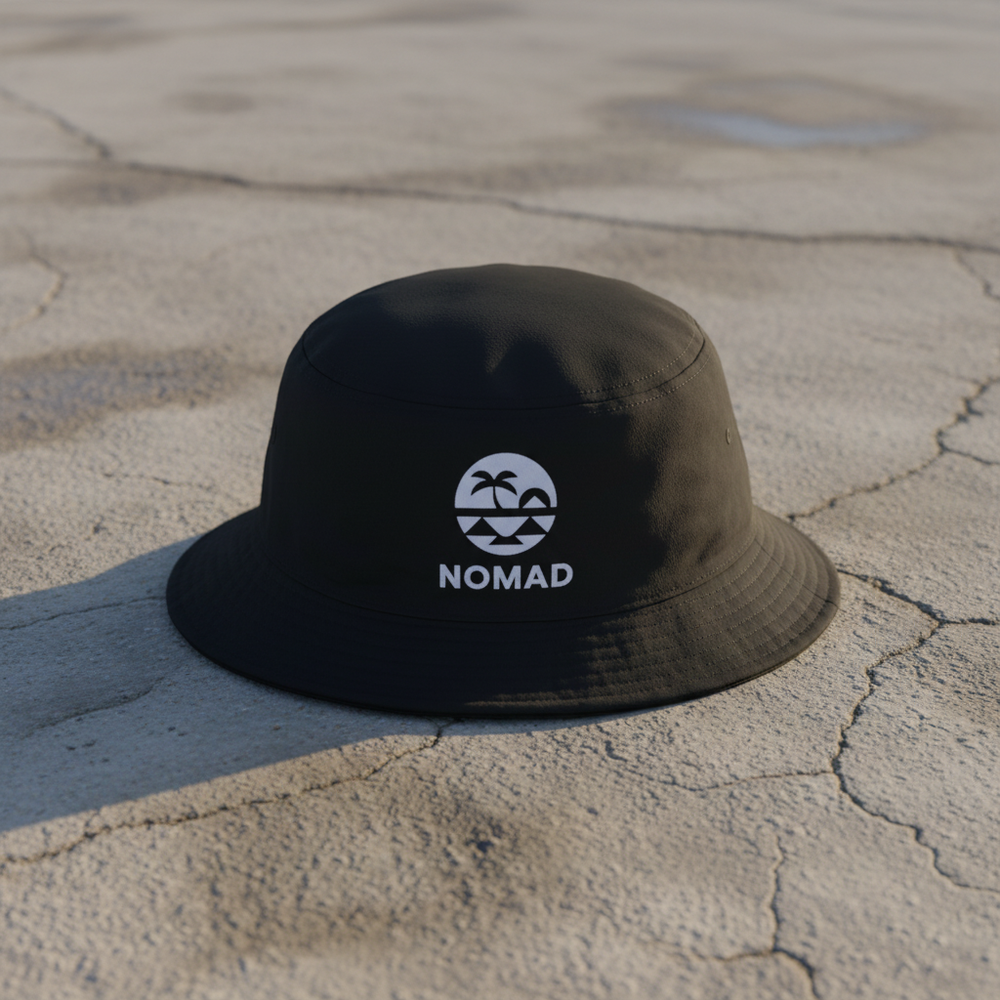 Nomad black bucket hat on light cracked cement with wet marks