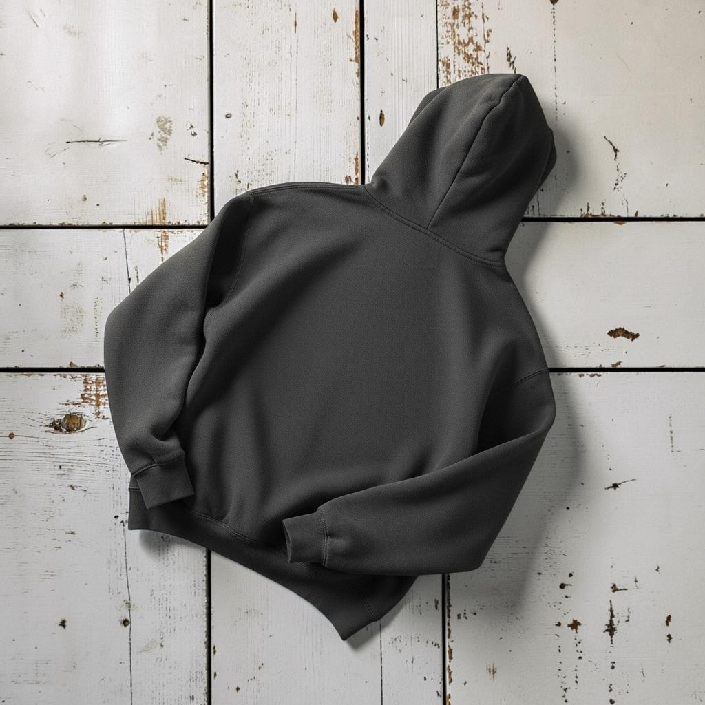 The Rusty Hook Hoodie in Pepper — back view, warm sand studio background