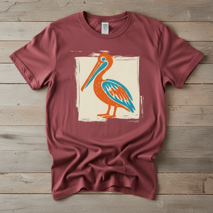 Colorful Beach Pelican chili garment-dyed tee on faded driftwood planks
