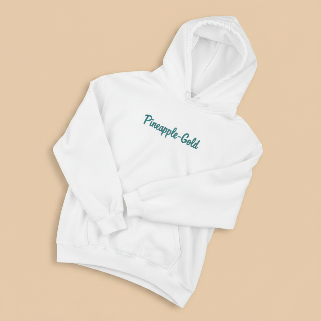 Pineapple-Gold Hoodie in White — front chest graphic, warm sand studio background